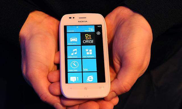 A man holds the new Nokia Lumia 710 smartphone at the Nokia World event in London