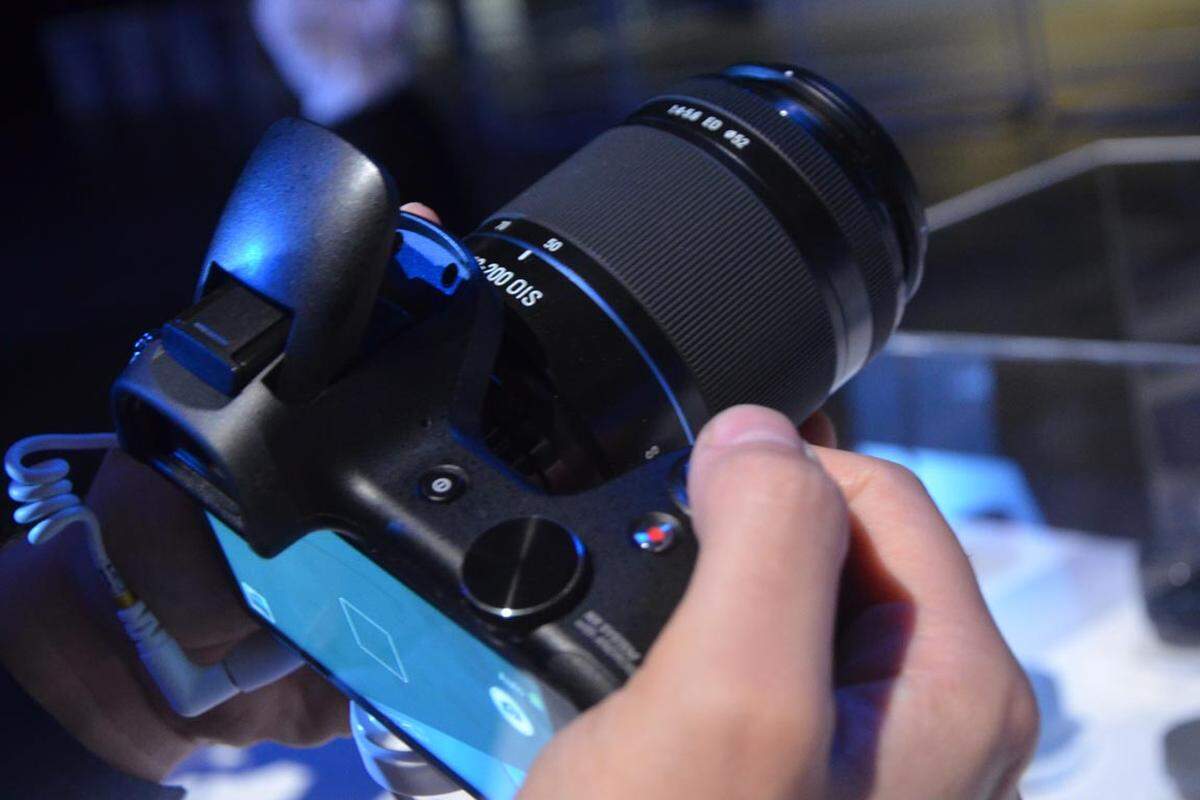 In erster Linie will die NX aber Kamera sein - hinter dem Buchstaben-Kürzel verbirgt sich immerhin Samsungs Systemkamera-Serie. Die Systemkamera lässt sich deshalb auch mit allen - derzeit 13 - Objektiven der NX-Serie bestücken (neu ist eine Fisheye-Linse). Der APS-C CMOS-Sensor löst mit 20,3 Megapixeln auf und die ISO-Werte reichen von 100-25.600. Zudem gibt es ein hybrides Autofokus-System.
