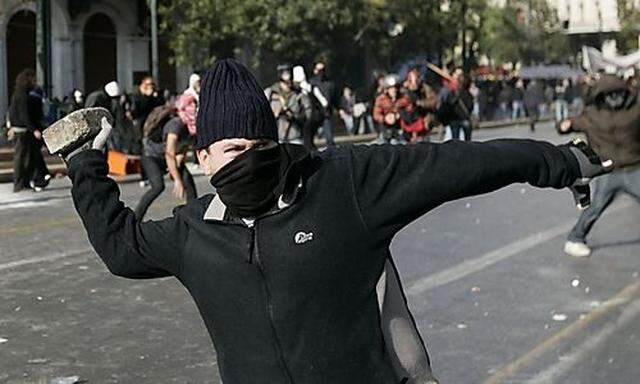 Ein Demonstrant wirft einen Stein in Athen.