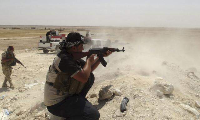 A tribal fighter aims his weapon during an intensive security deployment in Haditha