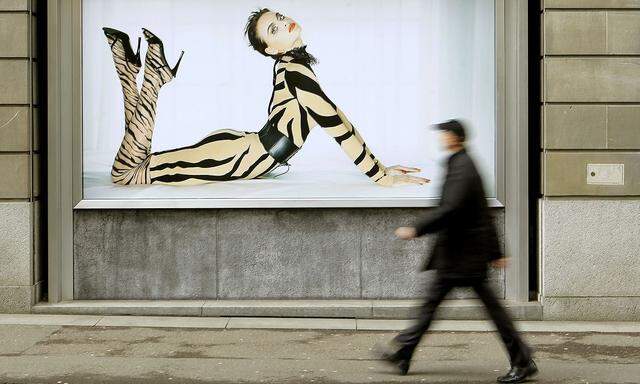 A man walks past an advertising poster of Austrian luxury hosiery group Wolford AG in Zurich