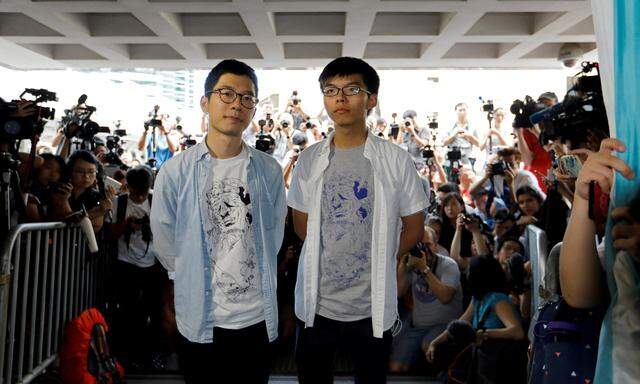 Student leaders Nathan Law and Joshua Wong arrive at the High Court to face verdict on charges relating to the 2014 pro-democracy Umbrella Movement, in Hong Kong