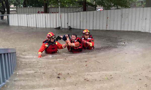Dieses am 4. September 2023 aufgenommene Foto zeigt Rettungskräfte, die in Xiamen in der südchinesischen Provinz Fujian einen Bewohner aus einem überschwemmten Gebiet in Sicherheit bringen.