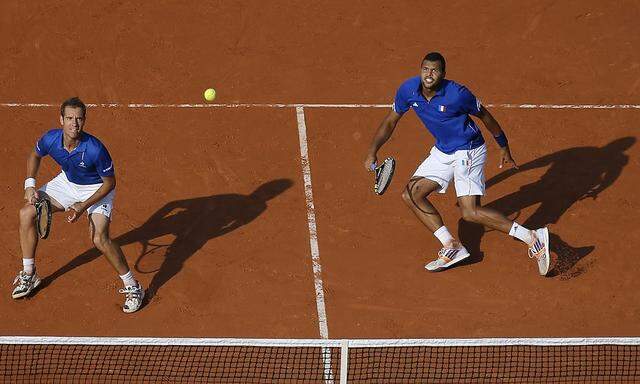 Tsonga and Richard of France hit a return during their Davis Cup semi-final doubles tennis match against Berdych and Stepanek of the Czech Republic in Paris