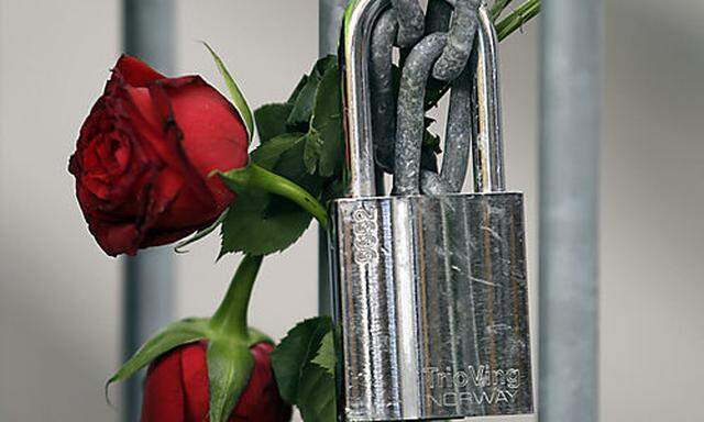 Roses are fixed on a fence to commemorate the victims in front of the Oslo court where Norwegian Ande
