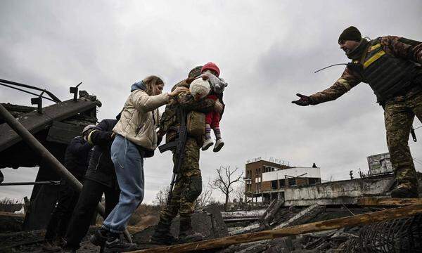 Ukrainische Soldaten helfen Zivilisten bei der Flucht – hier in Irpin nördlich von Kiew. 