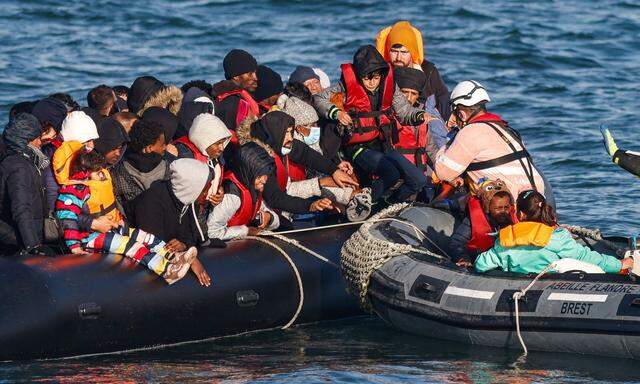 Ein kleines Boot bleibt im Ärmelkanal liegen- Rettungskräfte bringen die Migranten an Land.