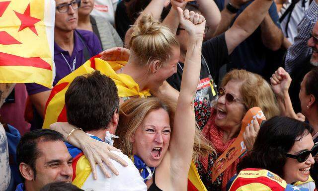 Viele Menschen beobachten auf großen Bildschirmen die Abstimmung im katalanischen Regionalparlament in Barcelona und brachen schließlich in Jubel aus.