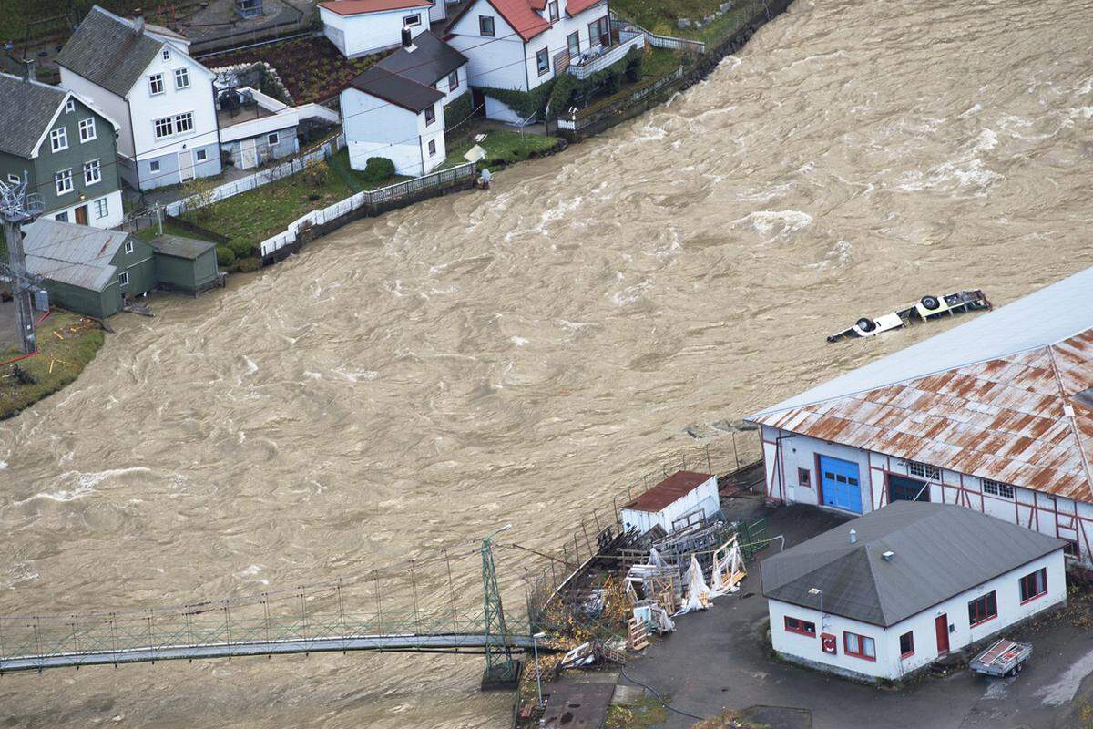 Einwohner im Westen des Landes konnten ihre Dörfer nicht mehr erreichen. Die Wassermassen spülten auch Autos weg.