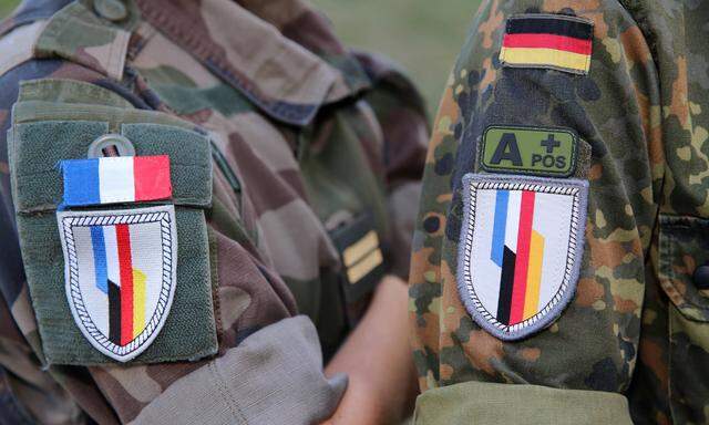 Archivbild: Zwei Soldatinnen der Deutsch-Französischen Brigade mit verschiedenen Uniformen. Links entsprechend das französische Tarnschema der Armee de Terre, rechts das Flecktarnschema der Bundeswehr.  