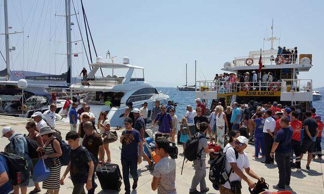 Tourists arrive from the Greek island of Kos by boat after an earthquake to the Turkish resort town of Bodrum