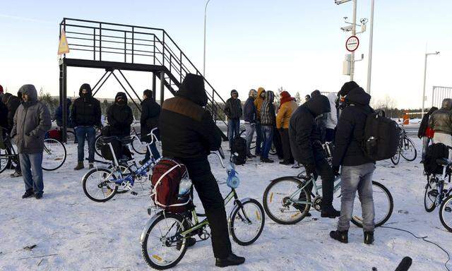 Refugees and migrants gather near a check point on the Russian-Norwegian border in Murmansk region