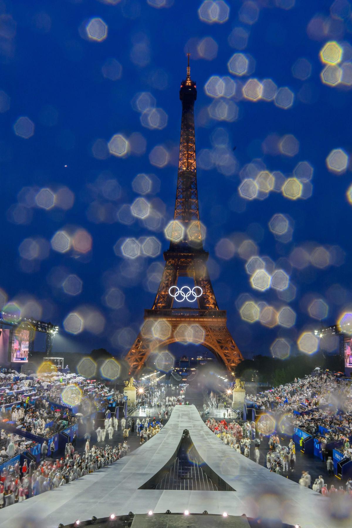 Overview of the Trocadero venue with the first delegation arriving, raindrops cover the lens, during the opening ceremony of the Paris 2024 Olympic Games in Paris on July 26, 2024, as the Trocadero is seen in the background. (Photo by Franois-Xavier MARIT / AFP)