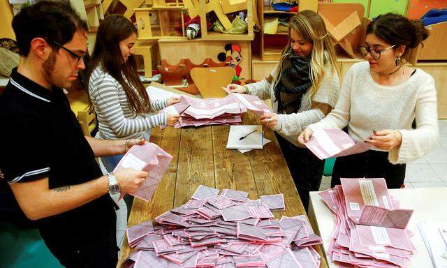 Volunteers count ballots for a referendum on constitutional reform at a polling station in Rome