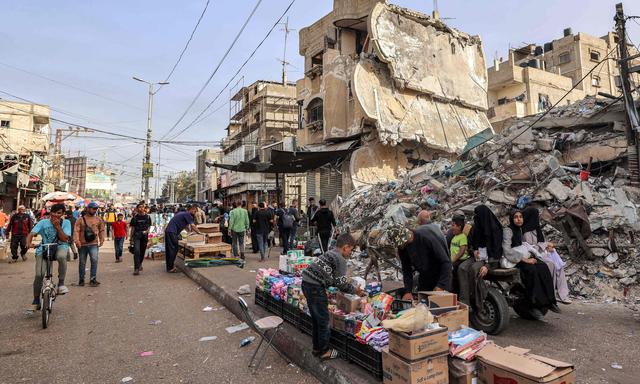 Ein Junge hilft einem Verkäufer in Rafah am 23. April, seine Waren zu ordnen.