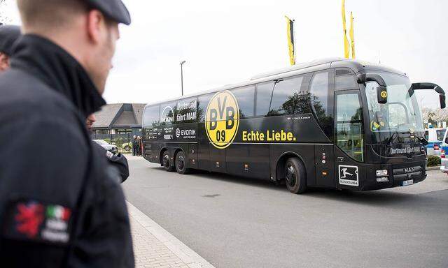 Erhöhte Polizeipräsenz beim Borussia-Trainingsgelände in Dortmund am Tag nach dem Anschlag; die Mannschaft wird in einem Ersatzbus befördert.