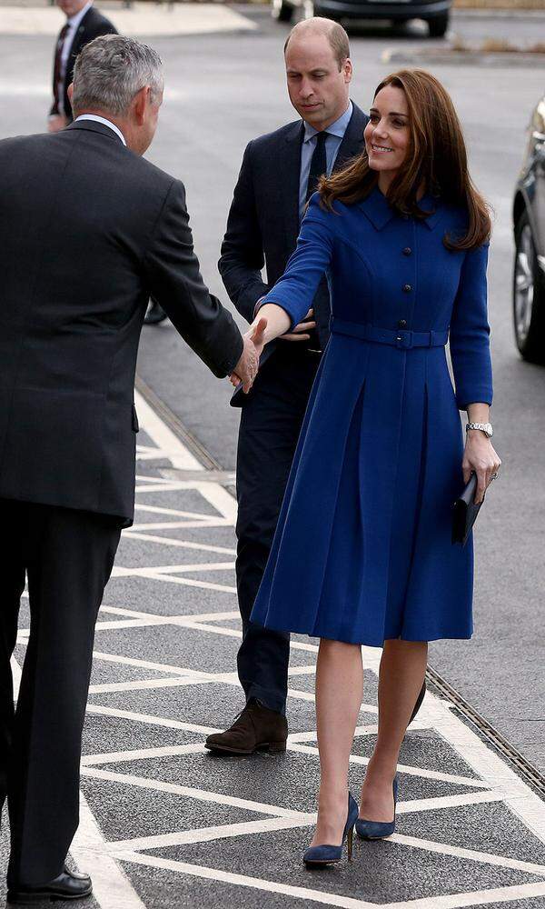 Royales Blau wählte die Herzogin an einem wahrlich royalen Tag: Auch wenn Schwiegervater Prinz Charles seinen 70. Geburtstag feiert, sind Prinz William und seine Frau für die Krone im Einsatz. Zur Eröffnung des „Composites Technology Centre“ von Sportwagen-Hersteller McLaren in Rotherham hüllt sich Kate in ein blaues Kleid mit Knopfdetails und Taillengürtel von Eponine. Die Leder-Clutch von Smythson passt nicht nur zum Kleid, sondern auch zu ihrem hochkarätigen Verlobungsring.