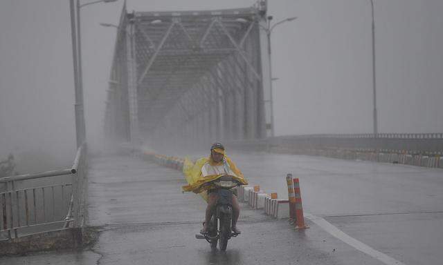 Taifun "Doksuri" hielt nicht alle in Vietnam davon ab, ihr Moped zu besteigen.