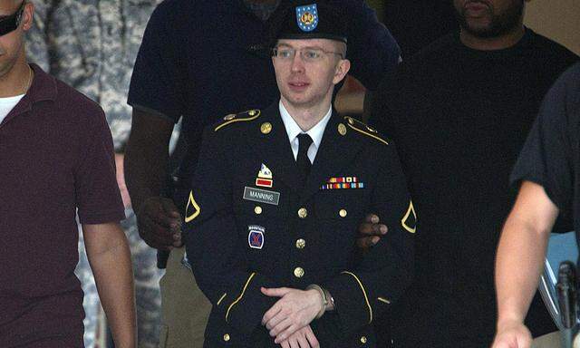 U.S. Army Pfc. Bradley Manning is escorted out of a courthouse at Fort Meade in Maryland