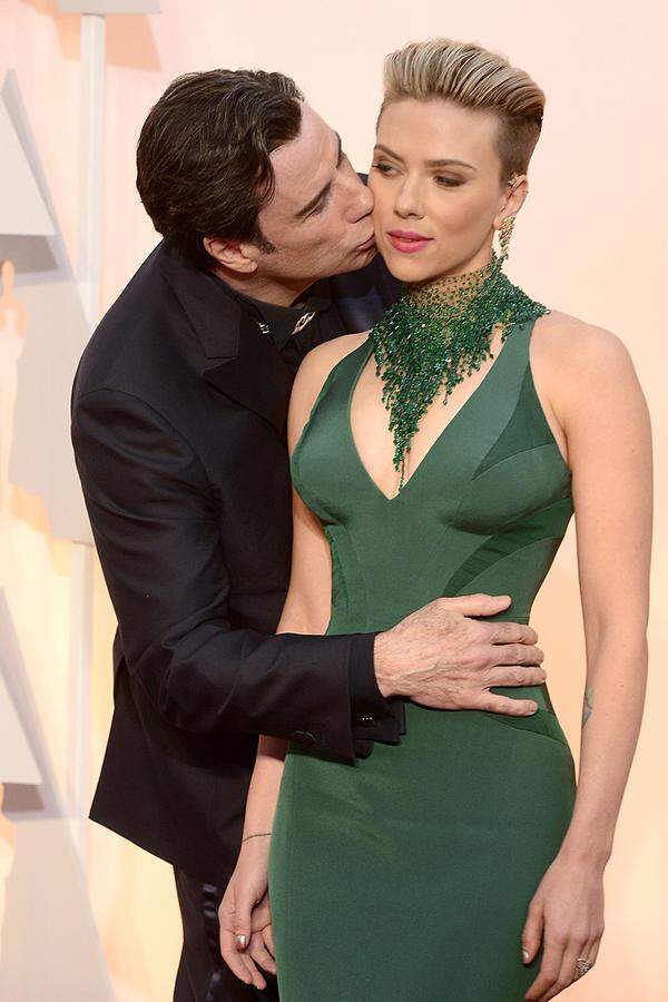 Scarlett Johansson trug zu ihrem verspäteten Undercut eine smaragdgrüne Robe von Versace. Das üppige Collier hat Swarovski entworfen. Von dem Bussi John Travoltas schien die Mimin nicht angetan.