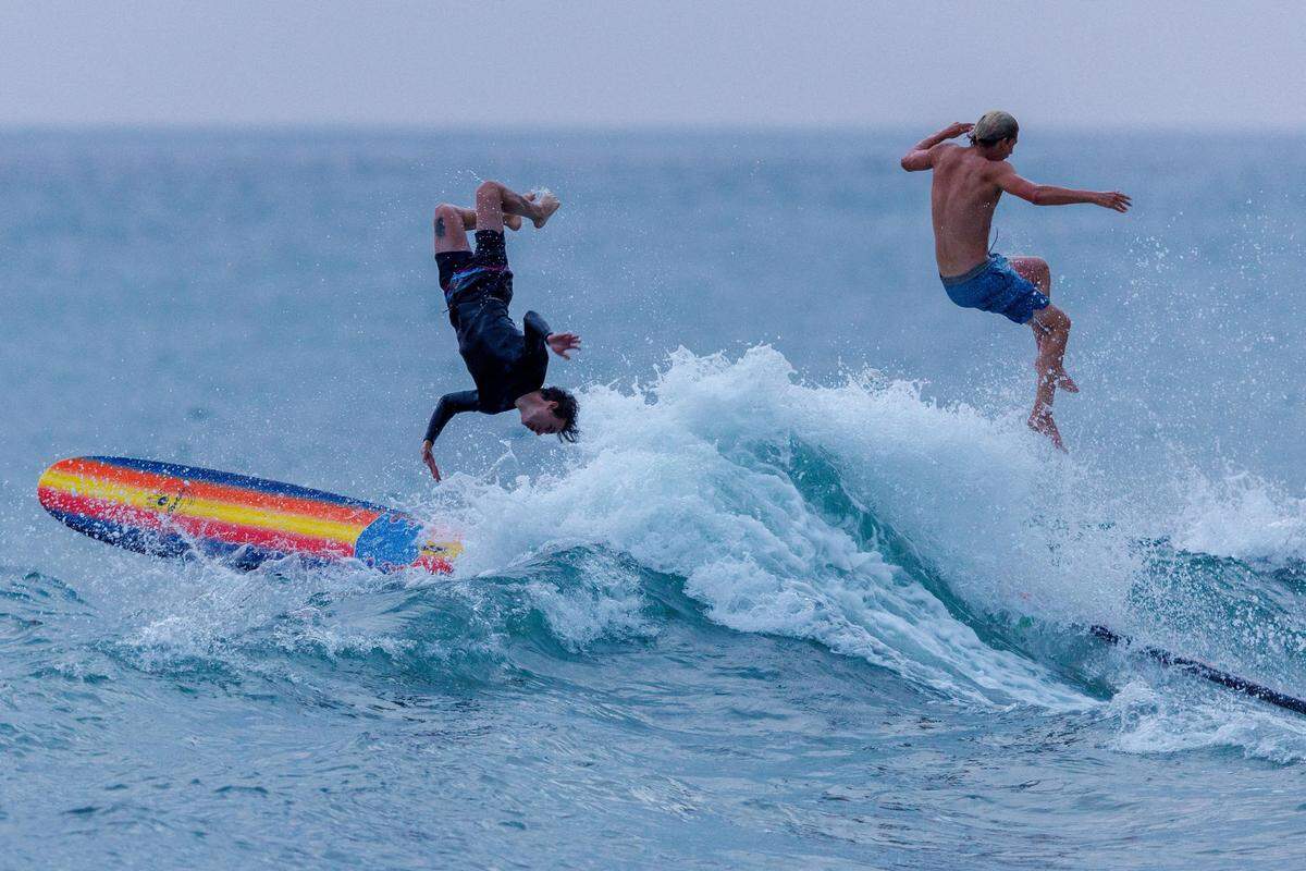 1. August. Die Surfer Sam Paulsen (re.) und Sean Bobo in den Wellen entlang der Klippenküste in Encinitas, Kalifornien.