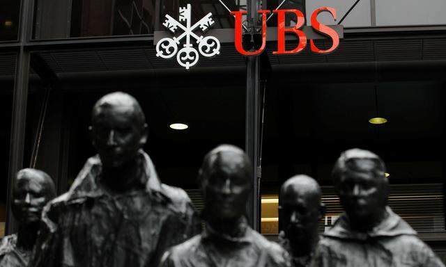 FILE PHOTO: Statues stand in front of the London office of Swiss bank UBS in London