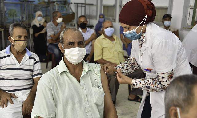 August 8, 2021, Tunis, Tunisia: A health worker administers the AstraZeneca vaccine to a Tunisian man at Oued Ellil hig