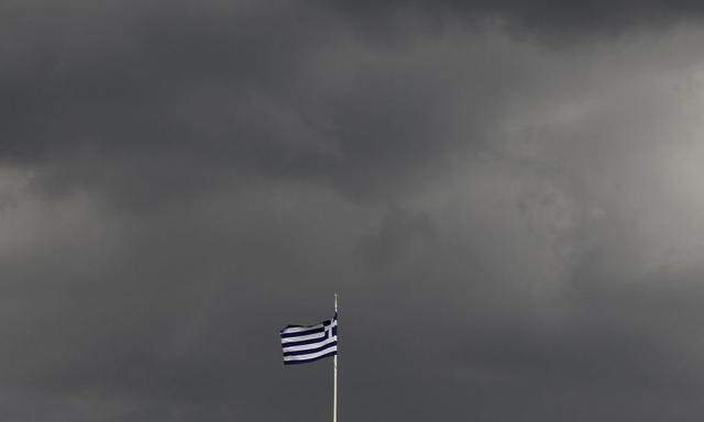 A Greek flag flutters under a cloudy sky in Athens