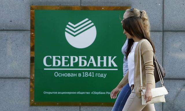 Women walk past an office of Sberbank in Moscow