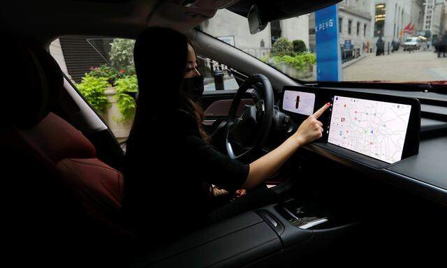 Eine Frau sitzt in einem Vorführ-E-Auto der chinesischen Marke XPeng Inc. P7.