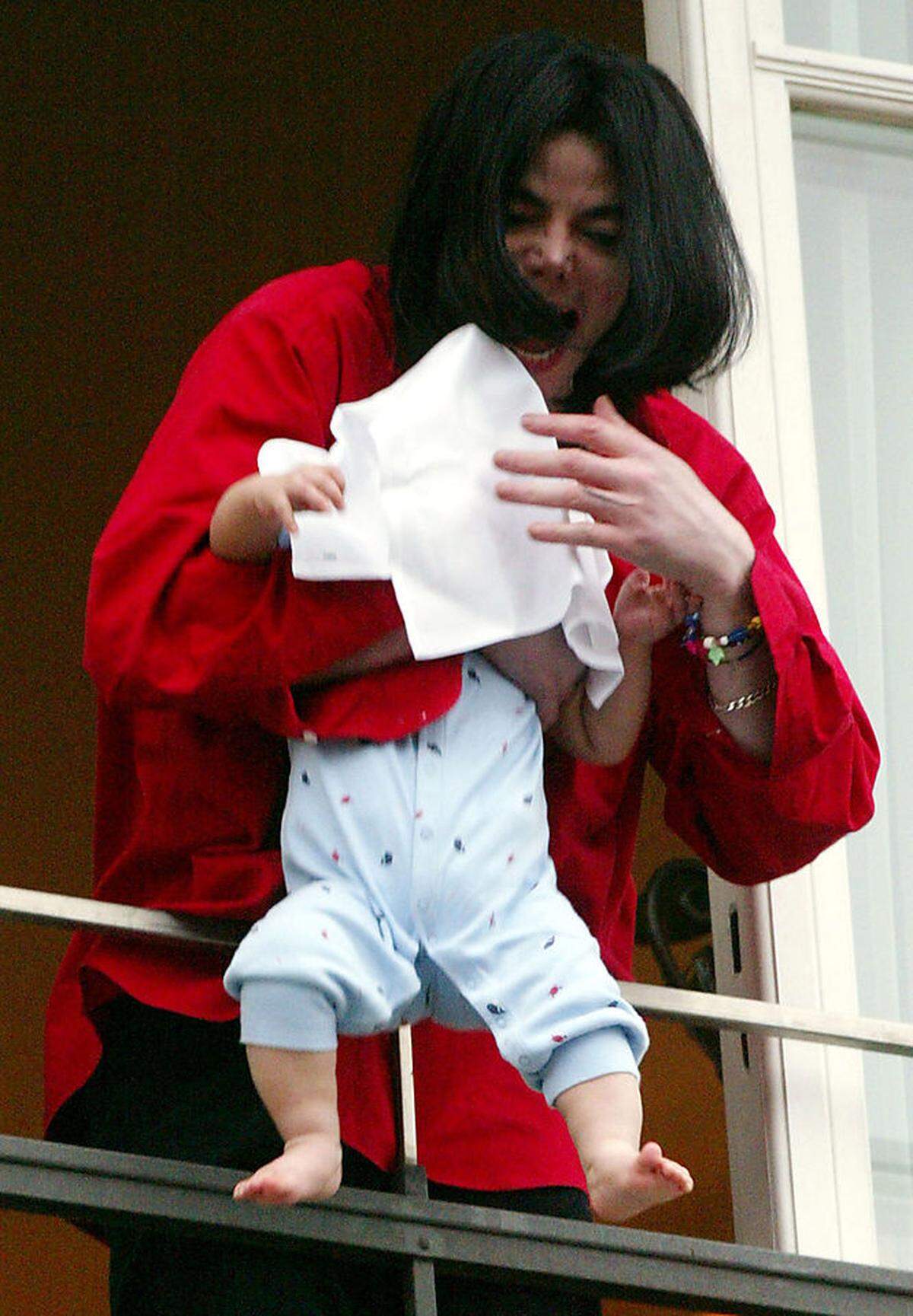 Allred widmete sich auch dem Popstar Michael Jackson. Nachdem der Musiker seinen neun Monate alten Sohn Blanket über den Balkon des Hotel Adlon in Berlin gehalten hatte (im Bild), meldete Allred den Fall bei der Familienbehörde in Los Angeles. Schon 1993 hatte sie einen Jungen vertreten, der Jackson des sexuellen Missbrauchs beschuldigt hatte.