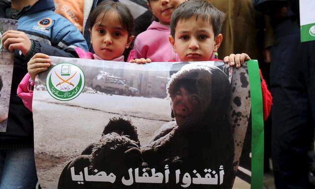 Children hold a poster during a sit-in organised by the Sunni Al Jama´a al-Islamiya group, calling for the lifting of the siege off Madaya, in front of the ICRC in Beirut