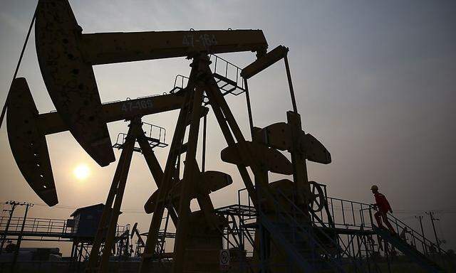 File photo of a worker examining a pumpjack at a PetroChina oil field in Panjin