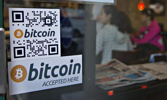 Signs on window advertise bitcoin ATM machine that has been installed in a Waves Coffee House in Vancouver