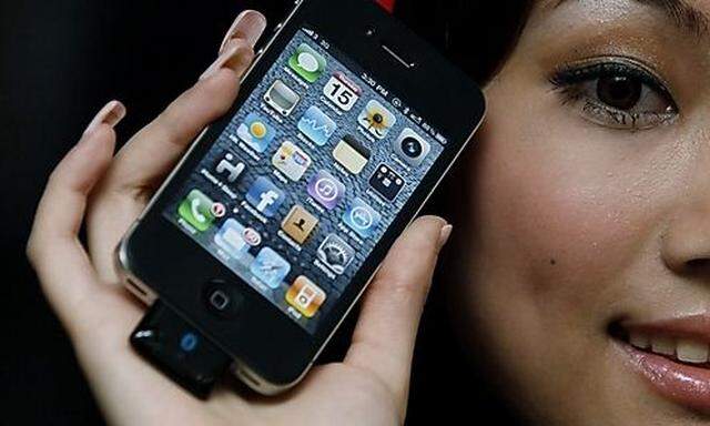 A model holds the latest iPhone 4 with bluetooth device during a promotional event in Hong Kong Thurs