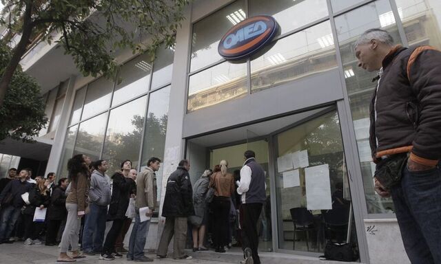 People wait for their turn outside an OAED office in an Athens suburb
