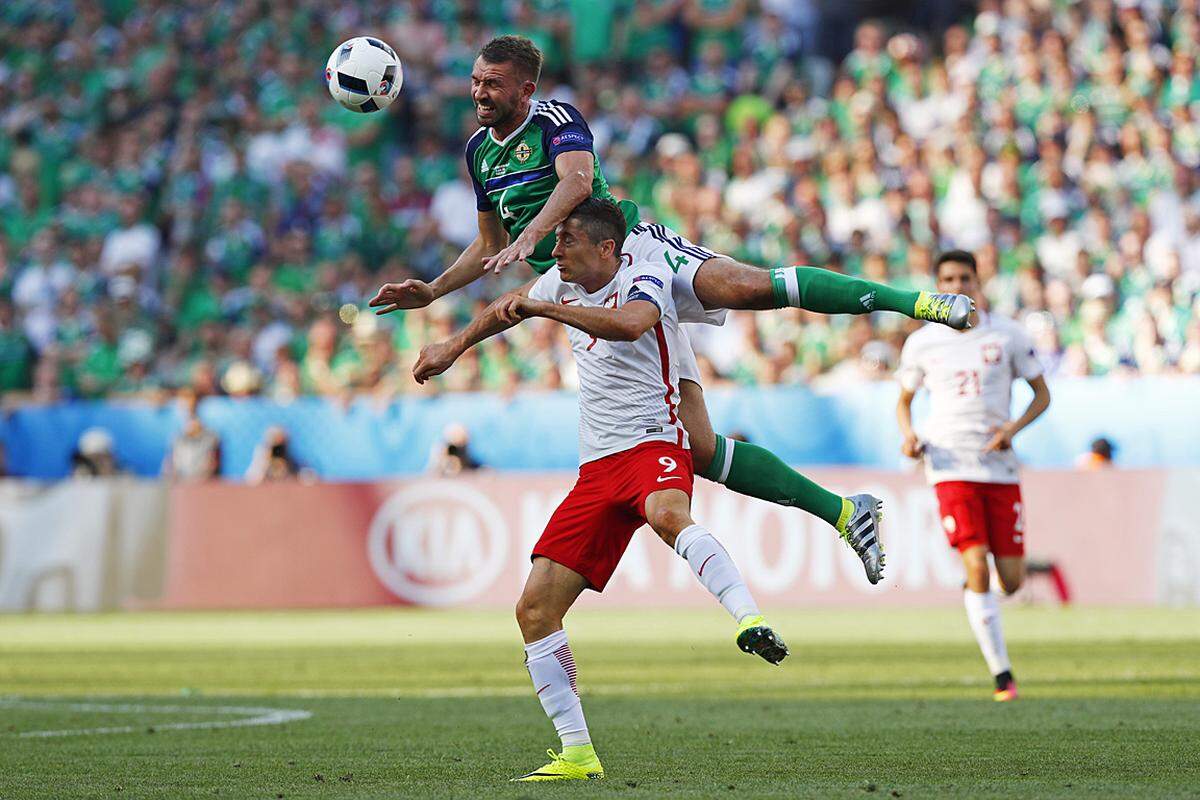 Wer trifft den Ball auch mit geschlossenen Augen, der Pole Robert Lewandowski (unten) oder der Nordire Gareth McAuley? Am Ende siegte Polen 1:0.