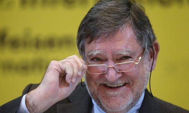 Raiffeisen Bank International CEO Herbert Stepic adjusts his glasses during a news conference in Vienna