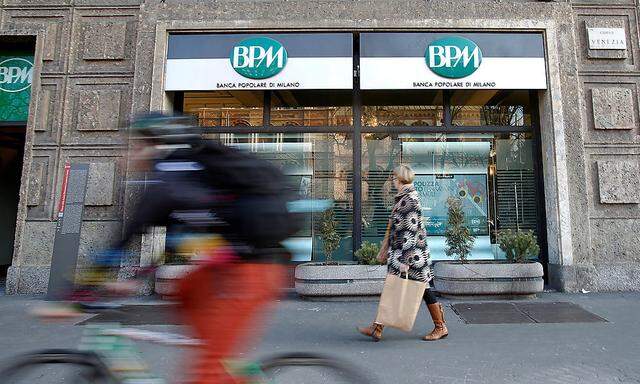 A woman walks in front of the Banca Popolare di Milano (BPM) bank in downtown Milan