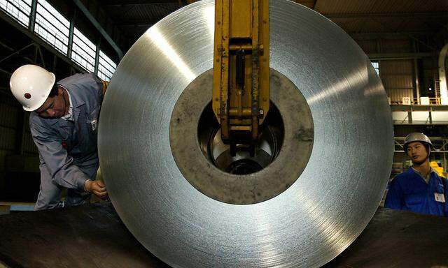 Chinese workers unload a roll of tin plate at Baosteel plant on the outskirts of Shanghai November 2..