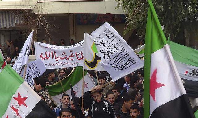 Demonstrators hold opposition flags during a protest against Syria's President Bashar al-Assad, in Jubar