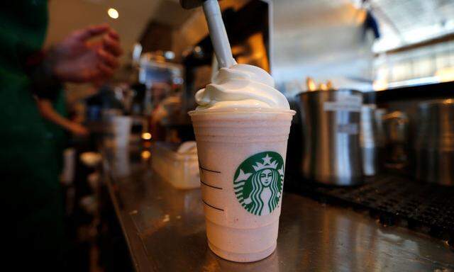 A barista puts whipped cream on a drink at a newly designed Starbucks coffee shop in Fountain Valley, California
