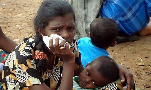 Tamil mother cradles her child at a refugee camp located on the outskirts of the town of Vavuniya in 