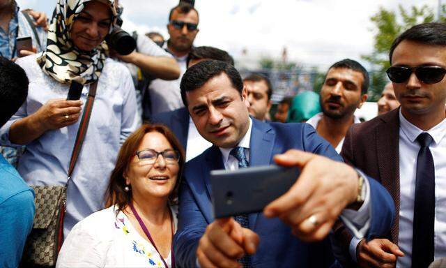 The leader of Turkey's pro-Kurdish opposition Peoples' Democratic Party Demirtas, takes a selfie with supporters during a rally in Istanbul