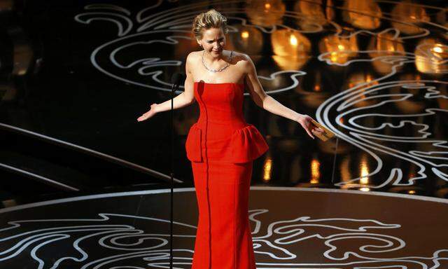 Actress Jennifer Lawrence takes the stage to present the Oscar for performance by an actor in a leading role at the 86th Academy Awards in Hollywood