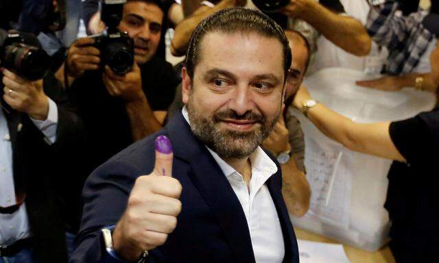 Lebanese prime minister and candidate for the parliamentary election Saad al-Hariri shows his ink-stained finger after casting his vote during the parliamentary election in Beirut