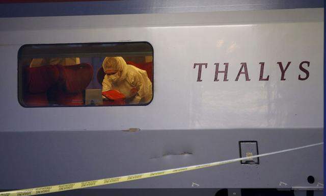 French investigating police in protective clothing collect clues inside the Thalys high-speed train where shots were fired in Arras 