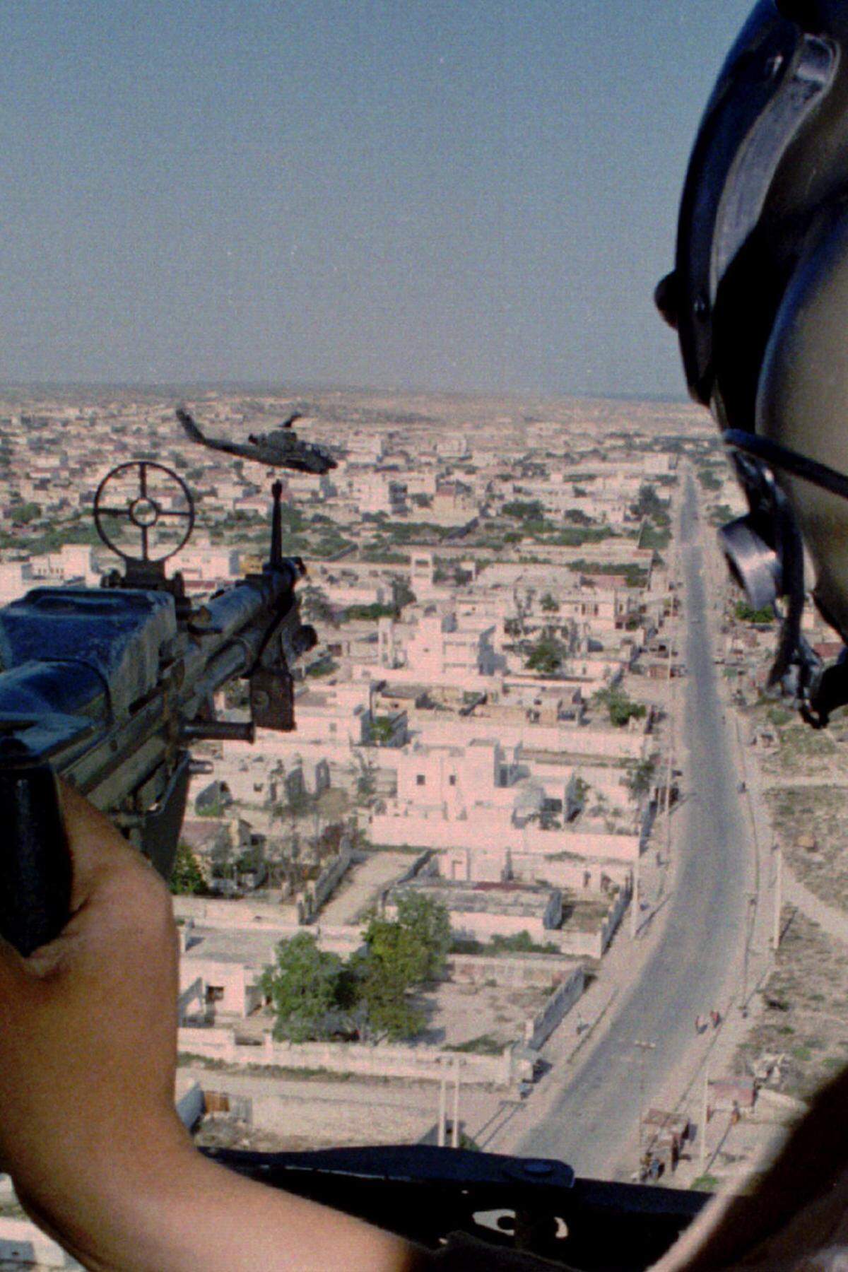 „Black Hawk Down“ - der Funkspruch, den US-Truppen in Somalia am 3. Oktober 1993 nach dem Abschuss eines Helikopters absetzen, markierte den Beginn einer Nacht, die als eine der größten Demütigungen in die Geschichte des US-Militärs eingehen sollte. 18 amerikanische Soldaten wurden bei der Schlacht von Mogadischu getötet, einige von ihnen von einer jubelnden Menge durch die Straßen geschleift. Die Fernsehbilder davon haben sich ins kollektive Gedächtnis Amerikas eingebrannt, das Debakel veränderte die Außenpolitik Washingtons grundlegend. (Bild: Black Hawk über Mogadischu, Oktober 1993)
