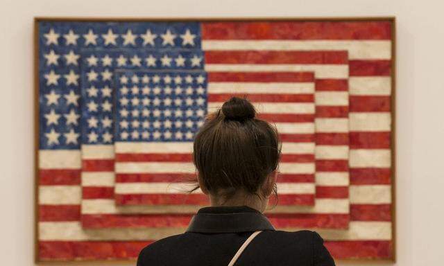 A woman looks at 'Three Flags' by Jasper Johns during the opening  preview at The Whitney Museum of American Art in New York
