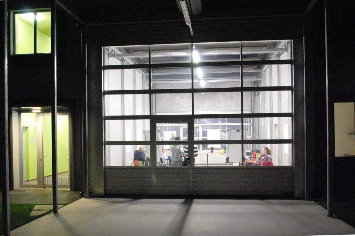 ...eine Garage. Zwei gläserne Selektionaltore ermöglichen eine maximale Ausdehnung des Raumes.